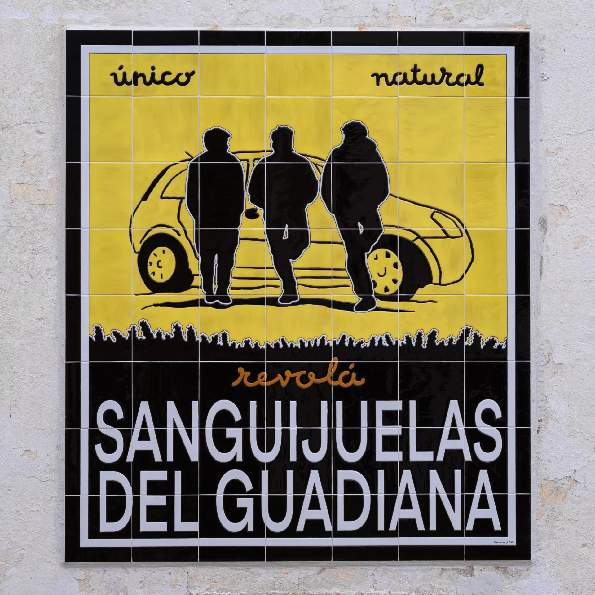 Mural de azulejos amarillos y negros de Sanguijuelas del Guadiana, con tres siluetas frente a un coche y el texto “único, natural, revolá